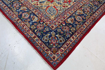 Corner detail of a red oriental rug with elaborate blue and cream border design homelooks.com