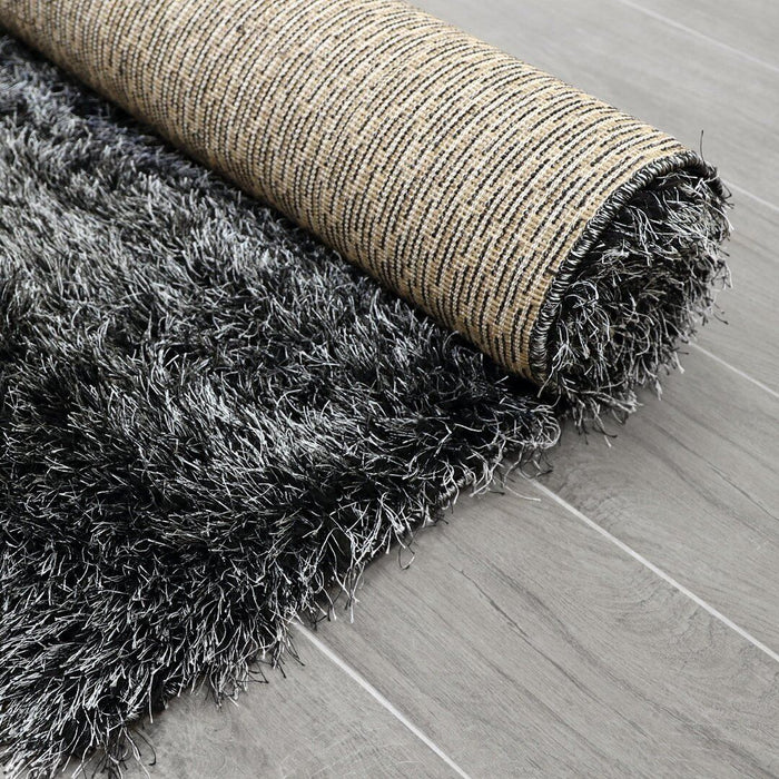 Lily Shimmer Dark Grey Shaggy Rug rolled up www.homelooks.com
