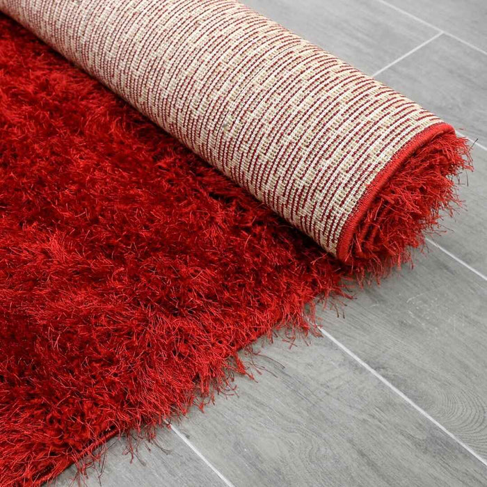 Lily Shimmer Red Shaggy Rug rolled up www.homelooks.com