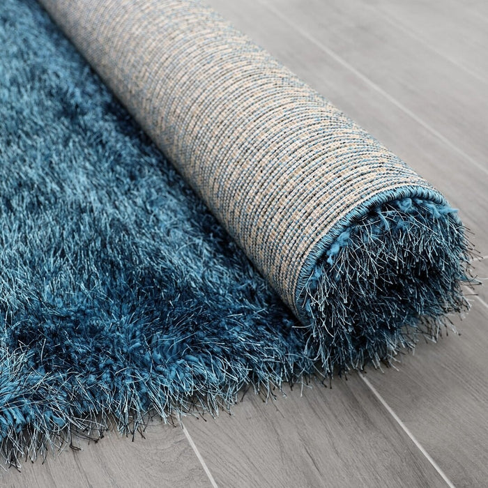 Lily Shimmer Turquoise Shaggy Rug rolled up www.homelooks.com
