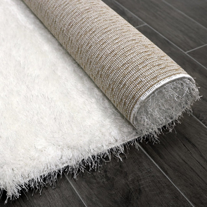 Lily Shimmer White Shaggy Rug rolled up www.homelooks.com